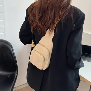 Beige corduroy crossbody chest bag with adjustable strap shown on a model