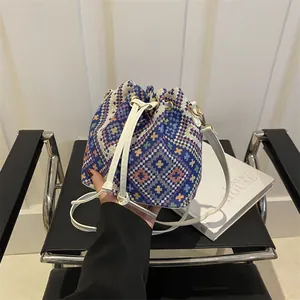 Borsa a secchiello in jacquard etnico con motivi geometrici blu e cinturini in pelle bianca
