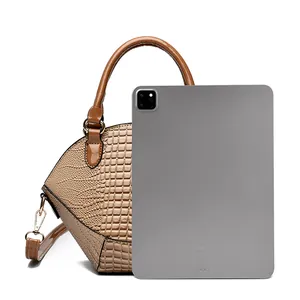Borsa a mano con trama a coccodrillo e iPad per riferimento di misura e capienza