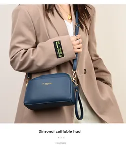Dettaglio della borsa a tracolla in pelle martellata blu navy con finiture dorate eleganti