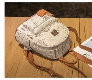 Detailed close-up of a mini backpack featuring letter print and a cute bear charm
