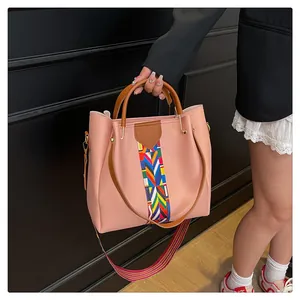 Dettaglio borsa a mano rosa con tracolla etnica colorata e fibbie in metallo oro