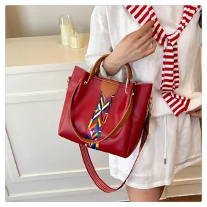 Dettaglio borsa rossa con tracolla intrecciata boho e motivo geometrico colorato