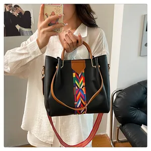 Dettaglio borsa a secchiello in pelle PU nera con riga etnica e tracolla in tessuto