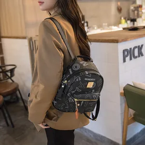 Chic black mini backpack with white letter prints and gold hardware for stylish women