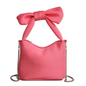 Sac seau rose chic avec anse à nœud papillon géant et bandoulière en chaîne argentée
