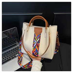 Dettaglio della borsa beige con motivo etnico e tracolla larga ricamata colorata