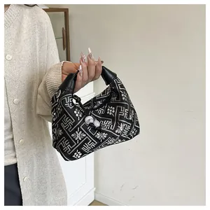 Detail of Chinese style embroidery on black fabric with elegant white pearl zipper pull