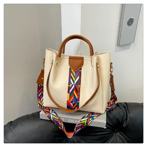 Dettaglio borsa shopper beige con tracolla etnica intrecciata e manici marroni