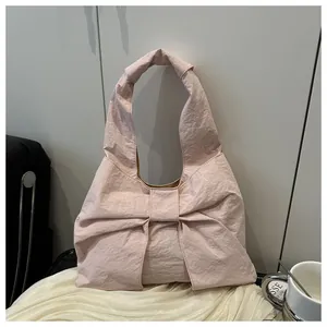 Dettaglio borsa tote rosa chiaro con fiocco oversize e trama in tessuto pieghettato