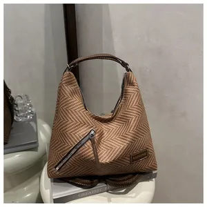 Detail of a brown woven hobo bag with a stylish herringbone texture and zipper pocket