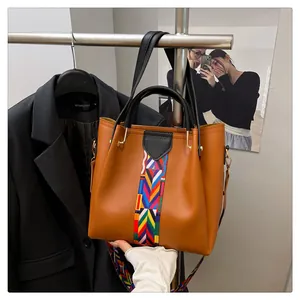Dettaglio borsa tote marrone in ecopelle con tracolla in tessuto stile etnico