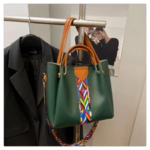 Dettaglio della borsa a mano in pelle verde con tracolla etnica in tessuto colorato