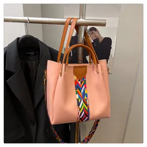 Dettaglio borsa tote rosa con tracolla intrecciata geometrica e manici marroni