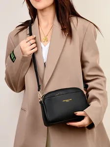 Borsa a tracolla nera minimalista con trama litchi e logo dorato da donna