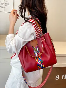 Borsa tote rosso intenso in ecopelle con tracolla etnica arcobaleno e manici marroni