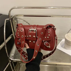 Burgundy punk-style baguette bag with silver rivets and metal grommets on leather strap