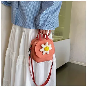 Close-up of pink canvas bag with 3D smiling daisy flower and adjustable strap