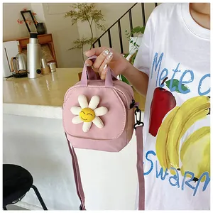 Detail of light pink canvas bag featuring a 3D daisy smile and adjustable strap