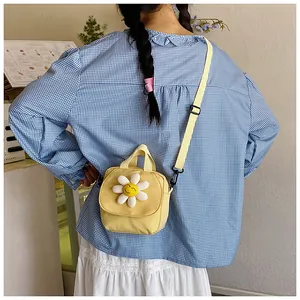 Detail of yellow canvas bag with 3D daisy flower on a crossbody shoulder strap
