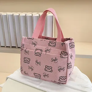 Detail der rosa Cord-Tragetasche mit Bärenmuster und praktischer Reißverschlusstasche