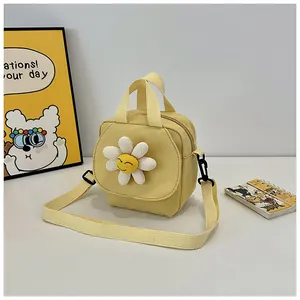 Detail of yellow canvas crossbody bag featuring a 3D daisy with smiley face and strap