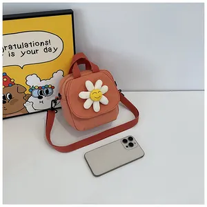 Detail view of brick red daisy canvas bag with yellow smiley face and woven strap