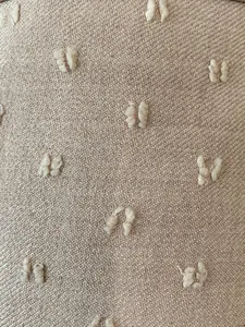 Macro shot of light pink woven fabric with clip spot textured tufts for shoulder bag