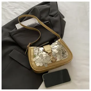 Detail of gold sequins and metallic lock on a stylish underarm bag for women