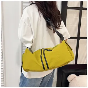 Detalle de la gran capacidad y correa negra ajustable de este bolso bandolera de nailon amarillo