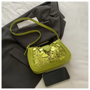 Close-up of vibrant neon green sequin shoulder bag with golden lock on a dark blazer
