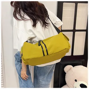 Detalle del bolso bandolera de nailon amarillo con gran capacidad y correa negra