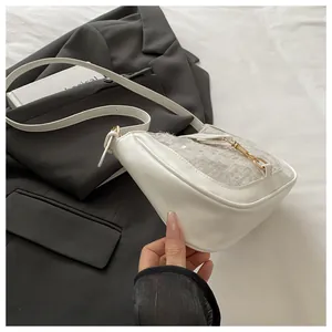 Detail shot of white shoulder bag featuring lace overlay and gold metal buckle clasp
