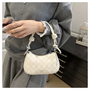 Detail der karierten Leder-Achseltasche mit geknotetem Schultergurt und Reißverschluss