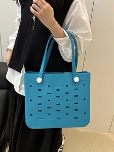 Blaue EVA Strandtasche von Model gehalten zeigt großes Volumen und gelochtes Design