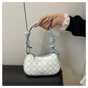 Detail der blauen Schachbrett-Handtasche mit Knotengurt und modischem Lederlogo