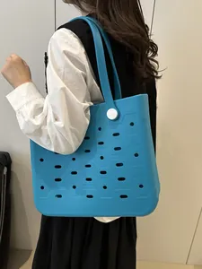 Große hellblaue EVA Strandtasche mit Lochmuster, getragen von einem Modell
