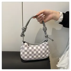 Detail der lila karierten Mondsichel-Tasche mit geknotetem Griff und Silberreißverschluss