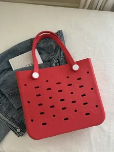 Detail der roten EVA-Strandtasche mit Lochmuster und stabilen Griffen für Reisen