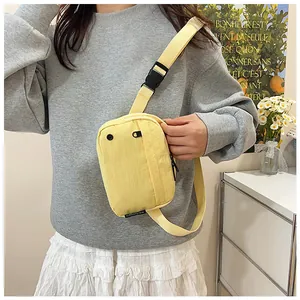 Close-up of pale yellow nylon crossbody bag featuring an adjustable strap and buckle