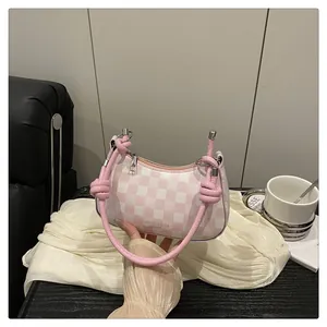 Detail der rosa-weiß karierten Hobo-Bag mit geknotetem Griff auf Seidenhintergrund