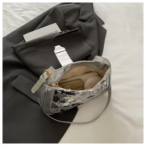 Detail view of silver sequin shoulder bag showing internal capacity and zip closure