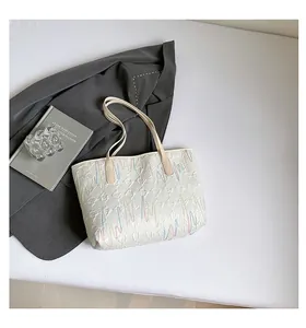 Close-up of quilted tote bag featuring colorful wavy embroidery and spacious interior