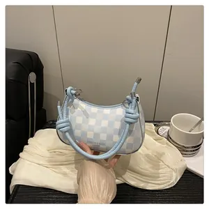 Details der blau-weiß karierten Schultertasche mit Knotengriff und Leder-Schriftzug