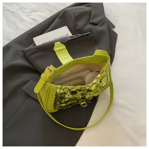 Close-up of bright green sequined shoulder bag showing internal storage for phone and makeup