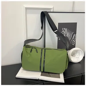 Detalle de bandolera de nailon verde de gran capacidad con correa negra ajustable