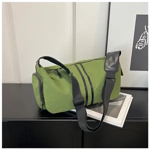 Detalle del bolso de viaje verde de nailon impermeable con bolsillo lateral y correa