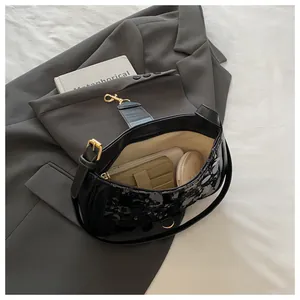 Interior view of black sequined shoulder bag showing space for phone and cosmetics