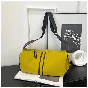 Detalle de bolso bandolera de nailon amarillo brillante con rayas negras