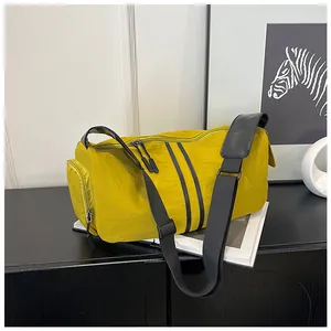 Detalle del bolso bandolera ligero amarillo con correas negras y cierres de cremallera